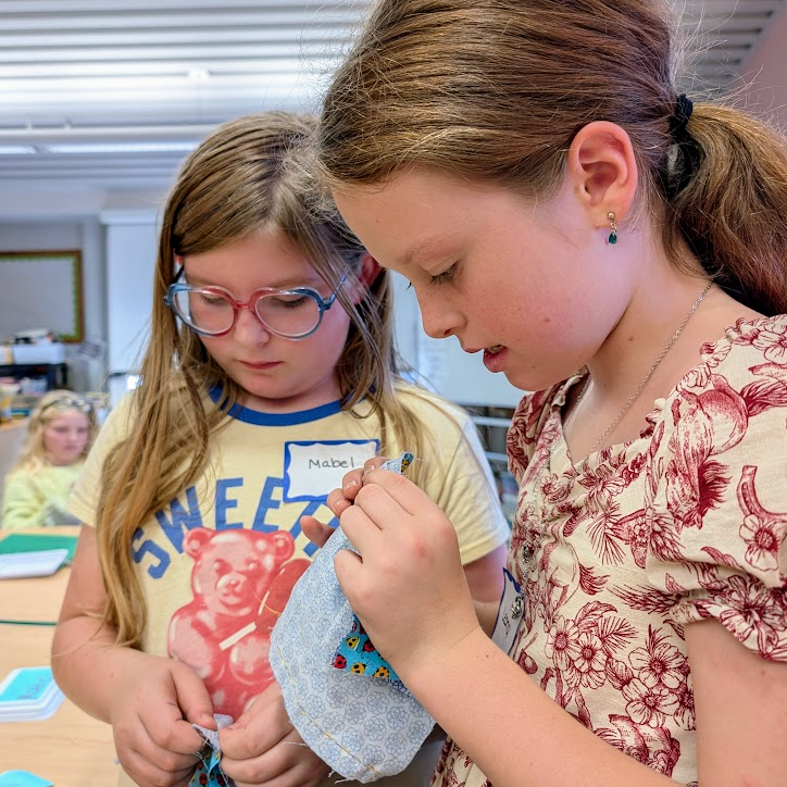 Students practice sewing.